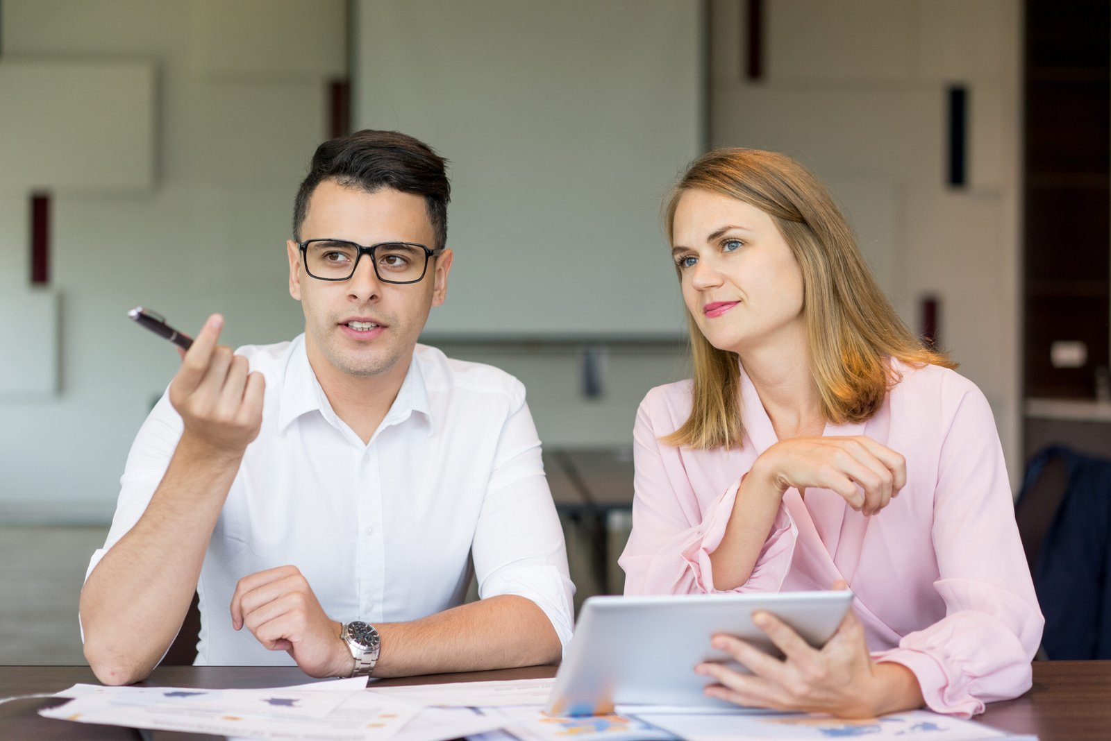 Confident businessman talking female colleague briefing scaled
